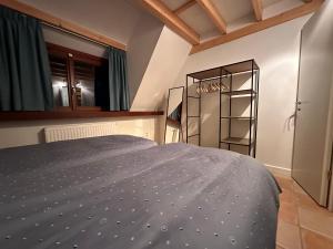 a bedroom with a bed with a blue comforter at Vakantiewoning Waag in Rekem