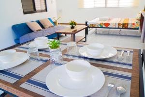 a dining room table with white dishes on it at LacambraHills Olongapo in Olongapo