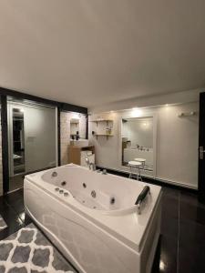 y baño con bañera blanca grande. en Loft des Célestins, en Vichy