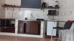 a kitchen with a counter and a chair in it at Kitnet em Aracaju para 3 pessoas in Aracaju