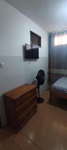 uma sala com um quarto com uma cama e uma cómoda em Kitnet em Aracaju para 3 pessoas em Aracaju