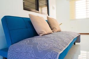 niebieskie łóżko z dwoma poduszkami na górze w obiekcie LacambraHills Olongapo w mieście Olongapo