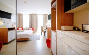 a hotel room with a bedroom and a bed and a kitchen at Apartment prywatny 725 Diwa SPA w kompleksie hotelowym w Kolobrzegu ul Kosciuszki 16 in Kołobrzeg