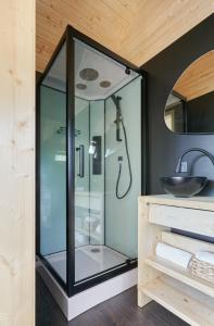 a glass shower in a bathroom with a sink at Forestic Lietuva in Vilionys +32 photos