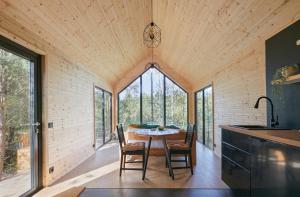 a kitchen and dining room with a table and chairs at Forestic Lietuva in Vilionys