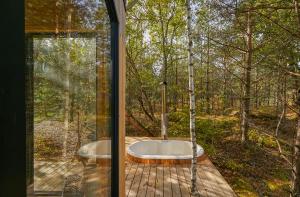a bathroom with a tub in the woods at Forestic Lietuva in Vilionys