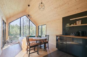 a kitchen and dining room with a table and chairs at Forestic Lietuva in Vilionys