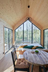 um quarto com uma mesa e uma grande janela em Forestic Lietuva 