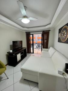 sala de estar con sofá blanco y TV en Apartamento 30 Mts Praia Balneário Camboriú, en Balneário Camboriú