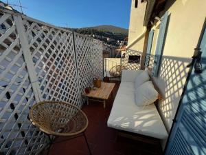- un canapé blanc sur un balcon avec une table et des chaises dans l'établissement Fenêtre sur Grasse, à Grasse