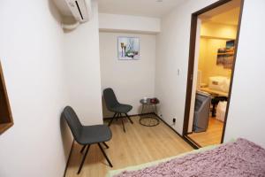 東京にあるShinjuku private homestay max 10pplのベッドルーム1室(椅子2脚、テーブル、鏡付)