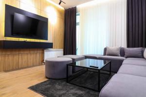 - un salon avec un canapé et une télévision dans l'établissement Ultra comfort apartment in NRG Oybek, à Yakkasaray