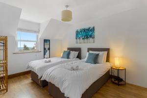 two beds in a room with white walls at Stunning Sea View Whole Home In Torbay Close To Beach in Torquay