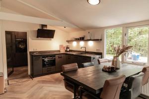 eine Küche mit einem Tisch und einer Arbeitsplatte in der Unterkunft Fenna's Holiday Home in Exloo
