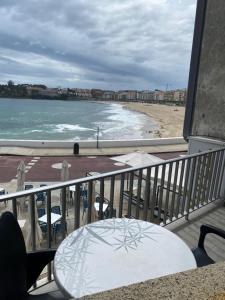 balkon ze stołem i widokiem na plażę w obiekcie Alojamientos Plaza Portugal w mieście Sanxenxo