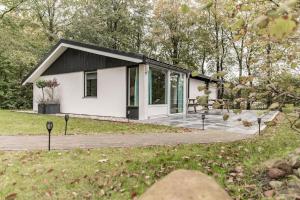 ein kleines weißes Cottage mit einem schwarzen Dach in der Unterkunft Fenna's Holiday Home in Exloo