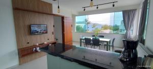Apartamento Praia do Sonho في باليوسا: مطبخ مع طاولة وغرفة طعام