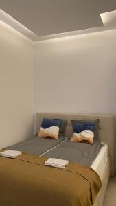 1 cama con 2 almohadas en una habitación en Hayat Apartments, en Izola