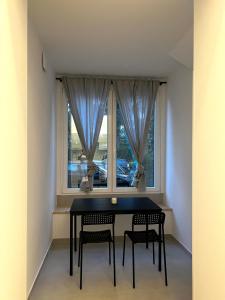 mesa de comedor con 2 sillas y ventana en Hayat Apartments, en Izola