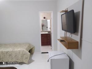 sala de estar con TV y dormitorio en Suíte praia dos Anjos, en Arraial do Cabo