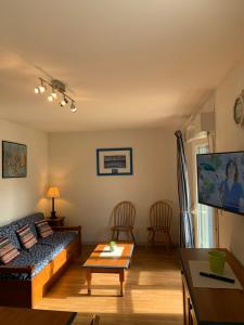 a living room with a couch and a table at Appartement T3 équipé in Carantec