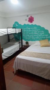 a bedroom with two bunk beds and a writing on the wall at Hostal 4 Manzanas in Santa Marta