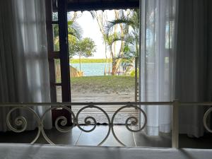 a bedroom with a window with a view of the ocean at Pousada ORIBÁ in Santo André