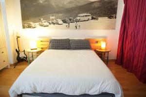 セルセディリャにあるLoft Puerto de Navacerradaのベッドルーム1室(大型ベッド1台、テーブル2台、ランプ2つ付)