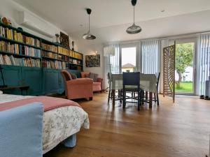 a bedroom with a bed and a dining room with bookshelves at Casa do Paço Aveiro Studio&Rooms in Aveiro