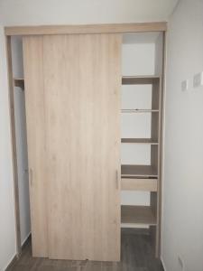 a closet with a wooden door in a room at Cataleya - Apartamentos in Marinilla