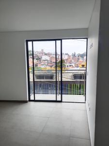 an empty room with an open door to a balcony at Cataleya - Apartamentos in Marinilla