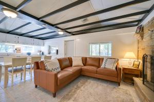 ein Wohnzimmer mit einem braunen Sofa und einem Tisch in der Unterkunft Charming Great Cacapon Cabin with Screened-In Porch! in Morton Grove