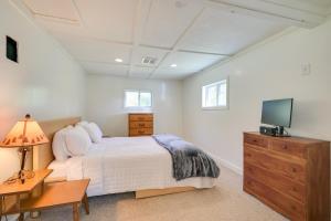 ein Schlafzimmer mit einem Bett und einem TV auf einer Kommode in der Unterkunft Charming Great Cacapon Cabin with Screened-In Porch! in Morton Grove
