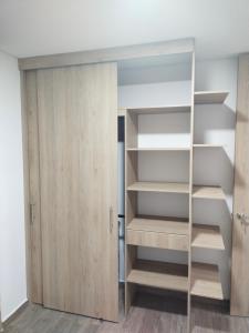 a closet with wooden shelves and a door at Cataleya - Apartamentos in Marinilla