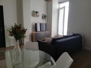 a living room with a couch and a glass table at CASA PALACIO CABALLEROS 7 con Parking in Sanlúcar de Barrameda