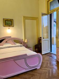 a large pink bed in a bedroom with a sliding glass door at Philo Hotel in Cairo