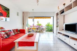 een woonkamer met een rode bank en een tv bij Casa Limona in Arona