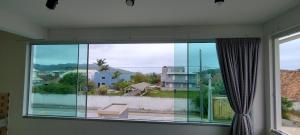 a large window with a view of a balcony at Apartamento Praia do Sonho in Palhoça