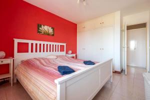 una camera da letto con pareti rosse e un letto bianco di Casa Limona ad Arona