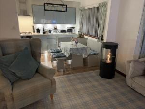 a living room with a table and a stove at Willow Lodge , Corskie Drive Macduff-Banff in Macduff