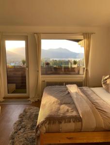 Un dormitorio con una cama y una ventana grande. en Apartment Sunset am Wolfgangsee, en Strobl