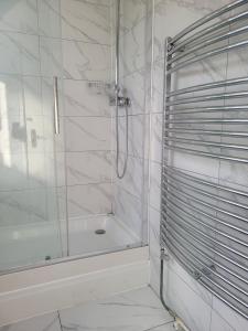 a white bathroom with a shower and a tub at Abakwa House in Kingsthorpe