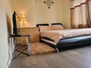 a bedroom with a bed and a desk with a television at Abakwa House in Kingsthorpe