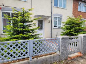 uma cerca em frente a uma casa com uma árvore de Natal em Abakwa House em Kingsthorpe