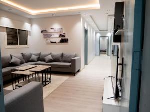 een woonkamer met een bank en een tafel bij Spacious apartments A in Riyad