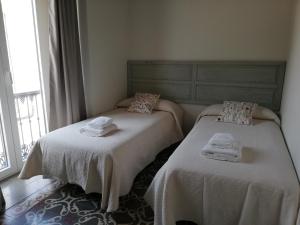 2 camas individuales en una habitación con ventana en CASA PALACIO CABALLEROS 7 con Parking, en Sanlúcar de Barrameda