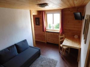 a living room with a couch and a table and a window at LOGIS Hôtel Restaurant La Vigotte in Girmont-Val-dʼAjol