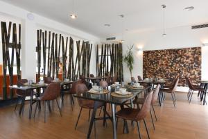 un restaurante con mesas y sillas y una pared de ventanas en Quinta d'Anta- Hotel Rural, en Maiorca