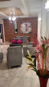 a living room with couches and chairs and a brick wall at CASA CON JACUZZI CENTRO PEREIRA in Pereira