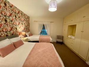 sypialnia z 2 łóżkami i oknem w obiekcie Canice Mooney Self Catering Holiday Home w mieście Drumshanbo
